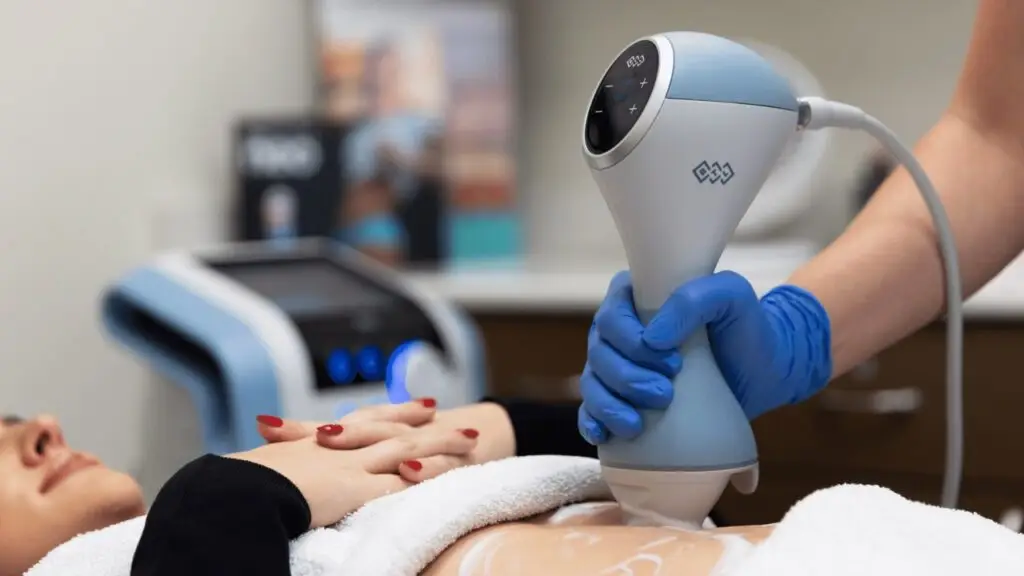 EMtone machine being applied to a female patients stomach