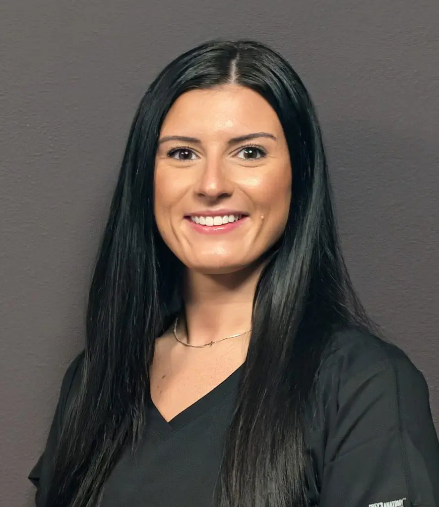 Headshot of a Female nurse with black hair in black scrubs